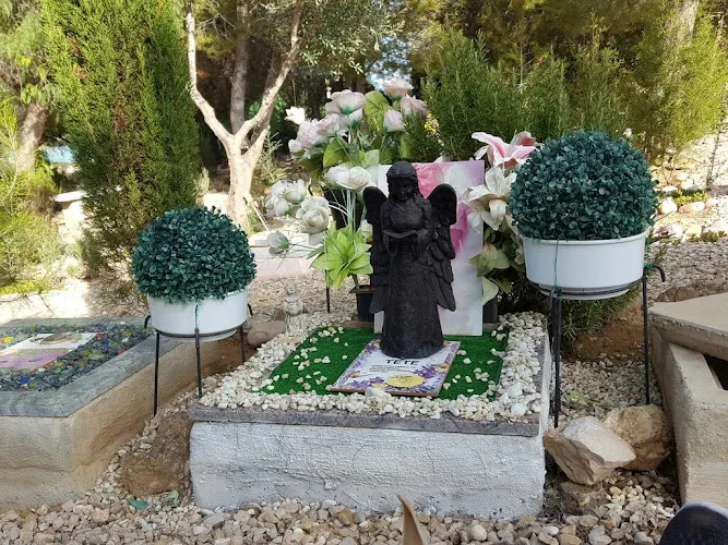 Tumba decorada con figura de ángel y flores en el cementerio de mascotas Sena Valencia