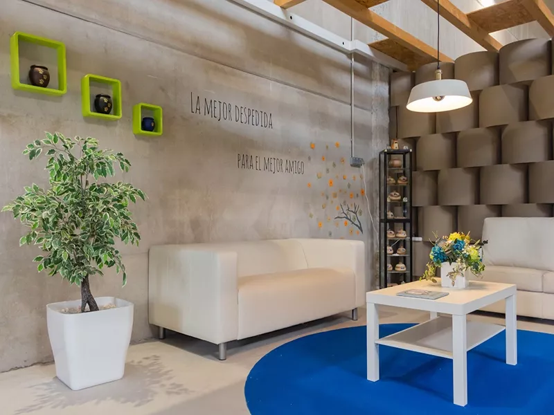 Sala de espera con sofás blancos y urnas en Paseo a las Nubes Crematorio de Mascotas, Burgos