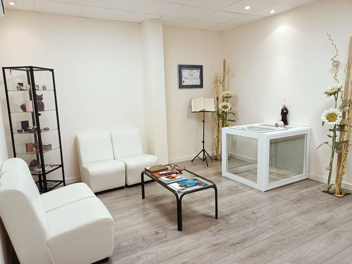 Sala de espera y recepción de Cremamur en Librilla Murcia, con sofás blancos, urnas expuestas y decoración floral
