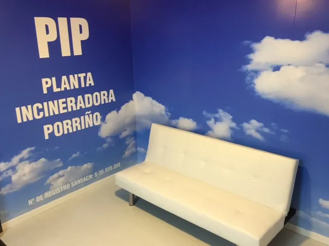 Sala de espera de PIP Planta Incineradora Porriño con sofá blanco y mural de cielo azul