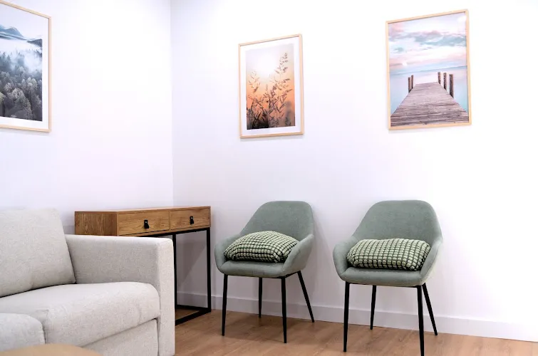 Sala de espera con sillas verdes y cuadros decorativos en Caelum Pets, tanatorio de mascotas en Barcelona